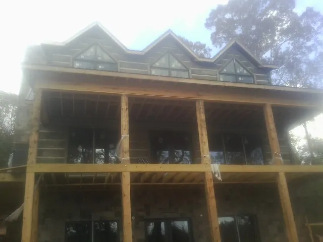 Dormers and porch framing on a large log home under construction — Roof Coating work by our crew in Middlefield