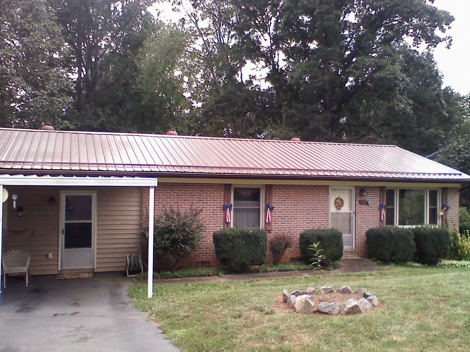Bronze metal roof and carport on a brick ranch home — Roof Repair work by our crew in Middlefield